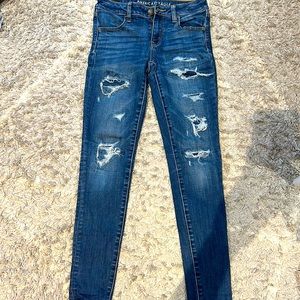 Dark blue jeans with rips and patches